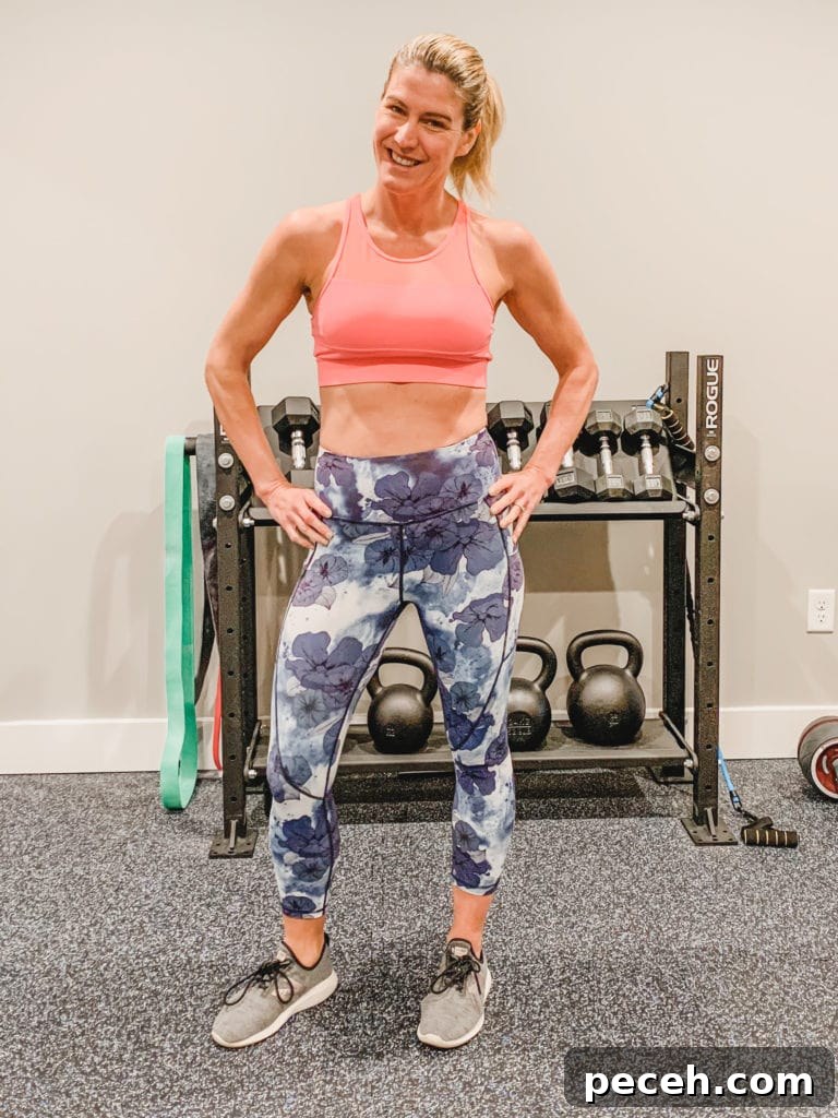 BOSU Ball Chest, Core & Quad Workout for Strength and Stability 9 A woman standing with her hands-on her hips wearing floral leggings and a pink sports bra