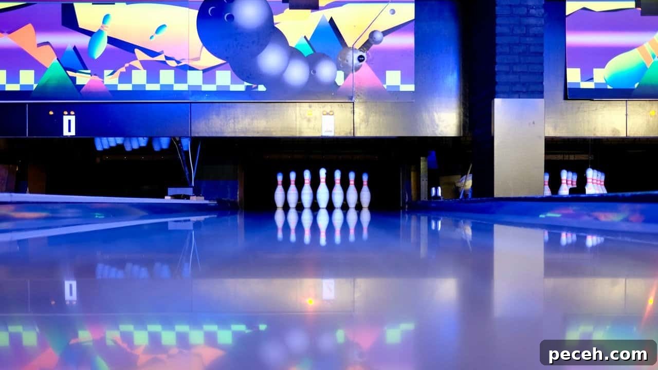 17 Fun and Memorable 13th Birthday Party Ideas 19 Bowling pins set on ground in neon bowling lane.