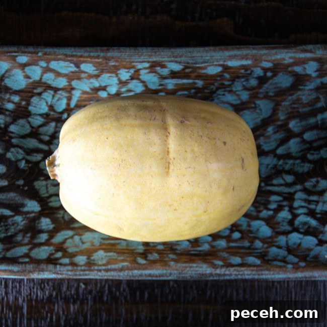 A spaghetti squash, whole, on a dish.