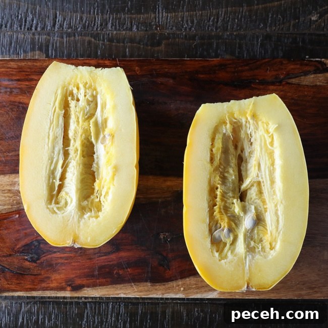A spaghetti squash sliced in half on a cutting board.