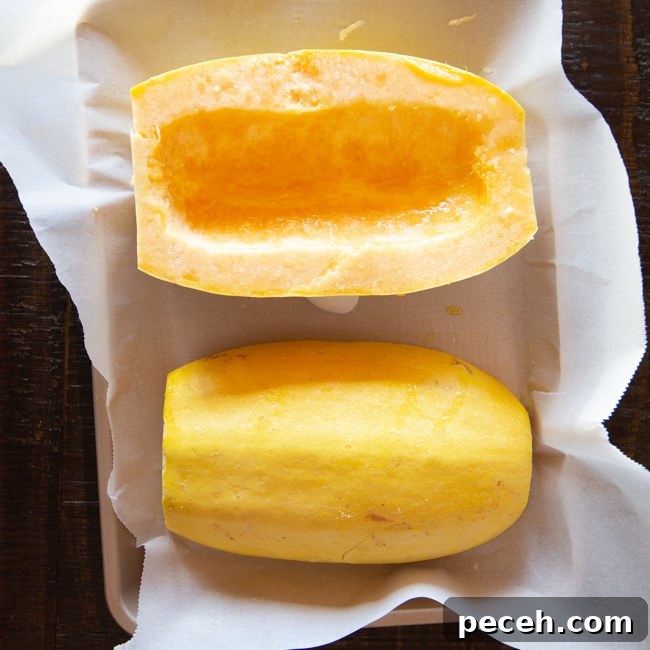 Two halves of a spaghetti squash, with one half turned up with all the seeds and pulp removed.