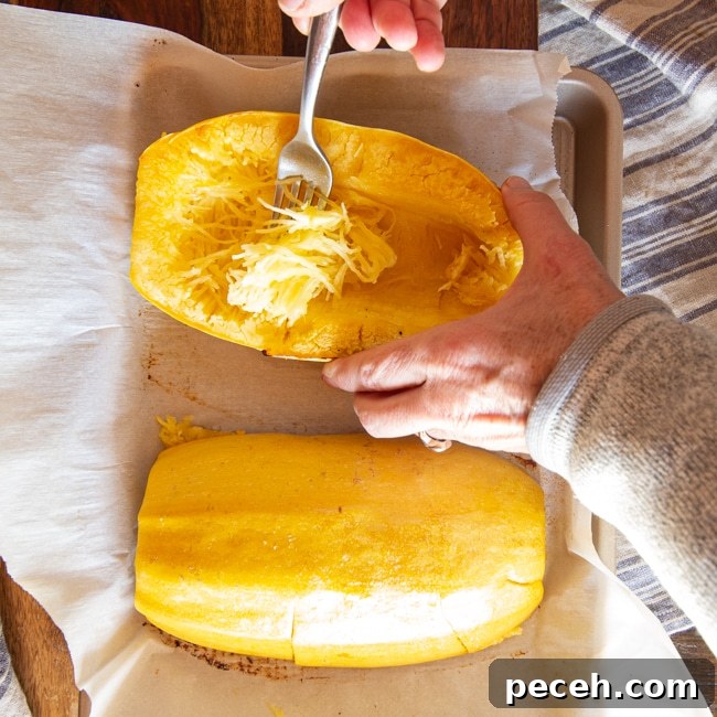 Pulling strands of spaghetti squash free with a fork.