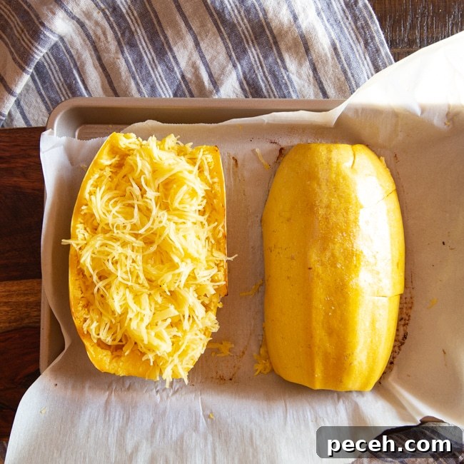 One half of a spaghetti squash cooked in the air fryer with all the strands pulled free.