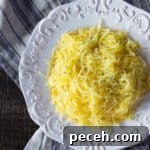 A platter of spaghetti squash cooked in the air fryer and sprinkled with freshly ground pepper.