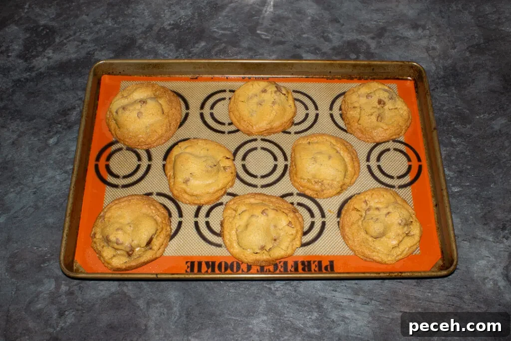 Crème Egg Cookie Recipe: Gooey Chocolate and Cadbury Filling 18 Baked Creme Egg cookies on a lined baking tray