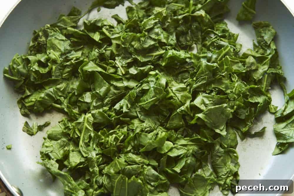 Kale and Walnut Pesto Recipe — Bright Sauce for Pasta & Toast 5 Cooked kale in a grey skillet.