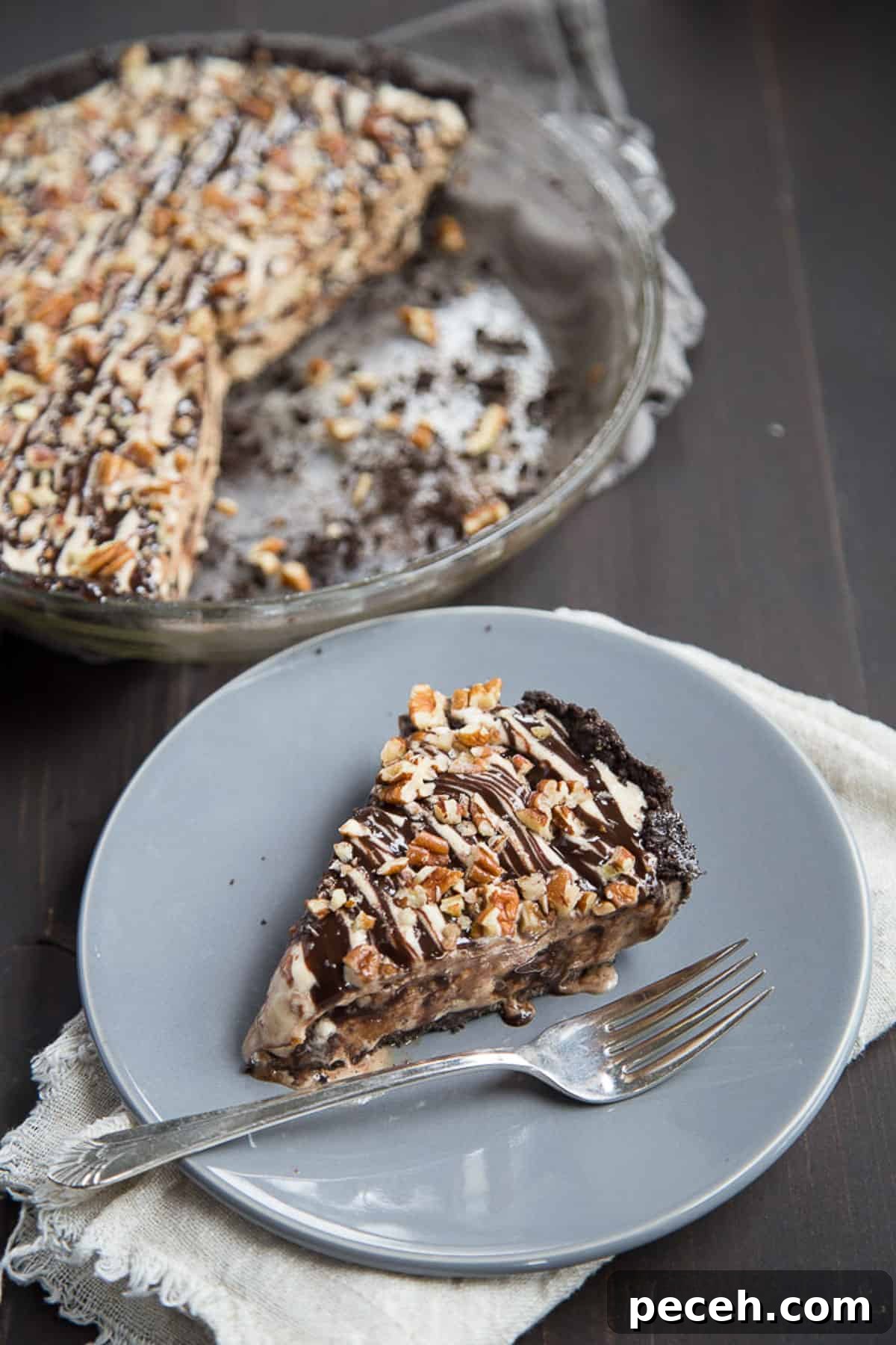 Decadent Mississippi Mud Ice Cream Pie Recipe 2 slice of mississippi mud ice cream pie on gray plate next to a whole pie.