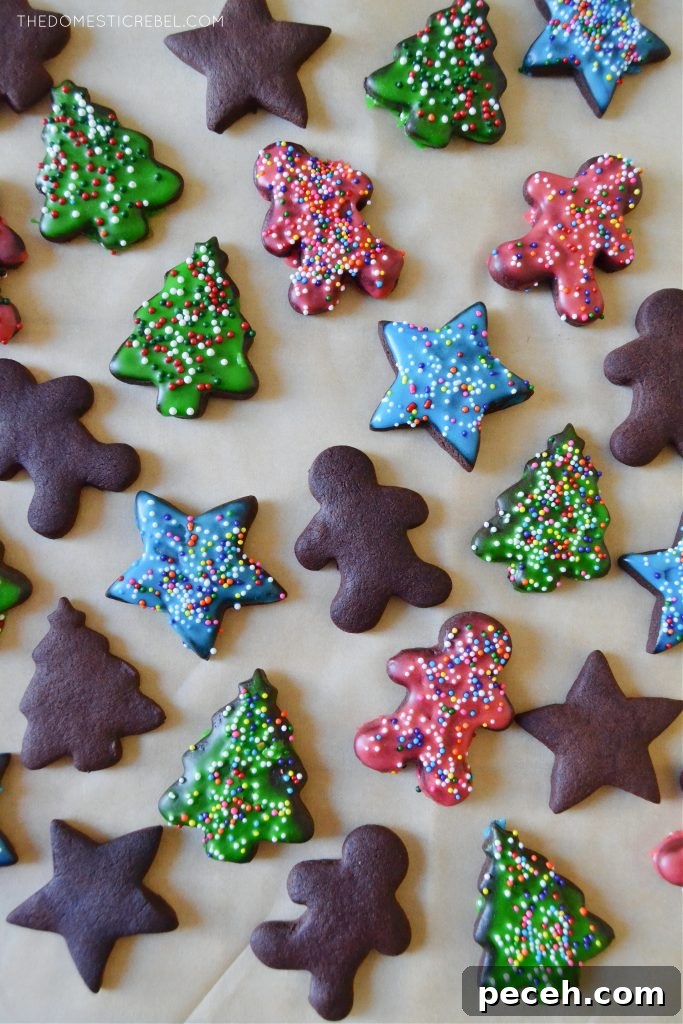 No-Chill Chocolate Cut-Out Sugar Cookies — Crispy, Ready Fast 3 an assortment of frosted and unfrosted chocolate sugar cookies on a brown piece of parchment