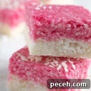 Coconut Ice Recipe: Creamy No-Bake Coconut Candy Tutorial 20 Two pieces of white and pink coconut ice stacked on top of each other.