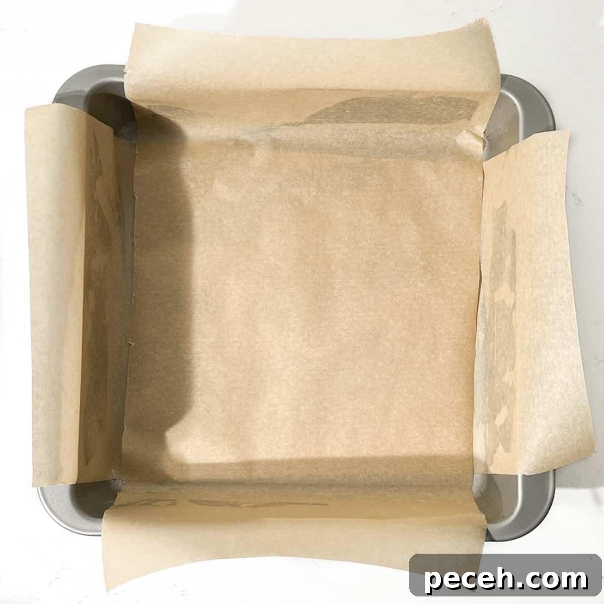 Coconut Ice Recipe: Creamy No-Bake Coconut Candy Tutorial 4 A square baking tin lined with baking paper.