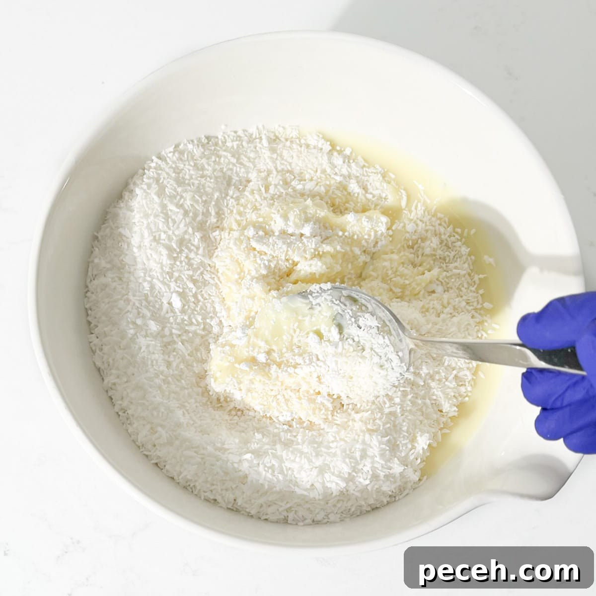 Coconut Ice Recipe: Creamy No-Bake Coconut Candy Tutorial 6 Mixing the mixture with a spoon.