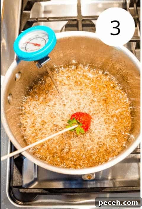 Tanghulu Candied Fruit Recipe — 3 Ingredients, Traditional Street Snack 4 A strawberry on a bamboo skewer being dipped into a pot with boiling sugar water in it.