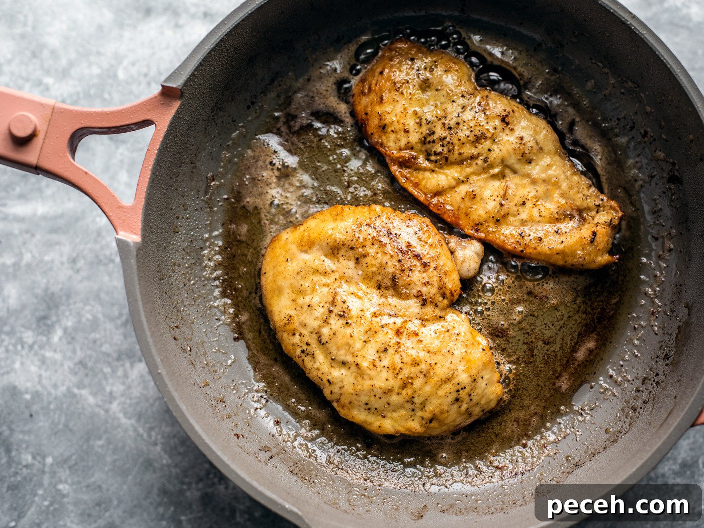 Classic Chicken Piccata Recipe with Lemon & Capers 6 Two golden chicken cutlets in a skillet.