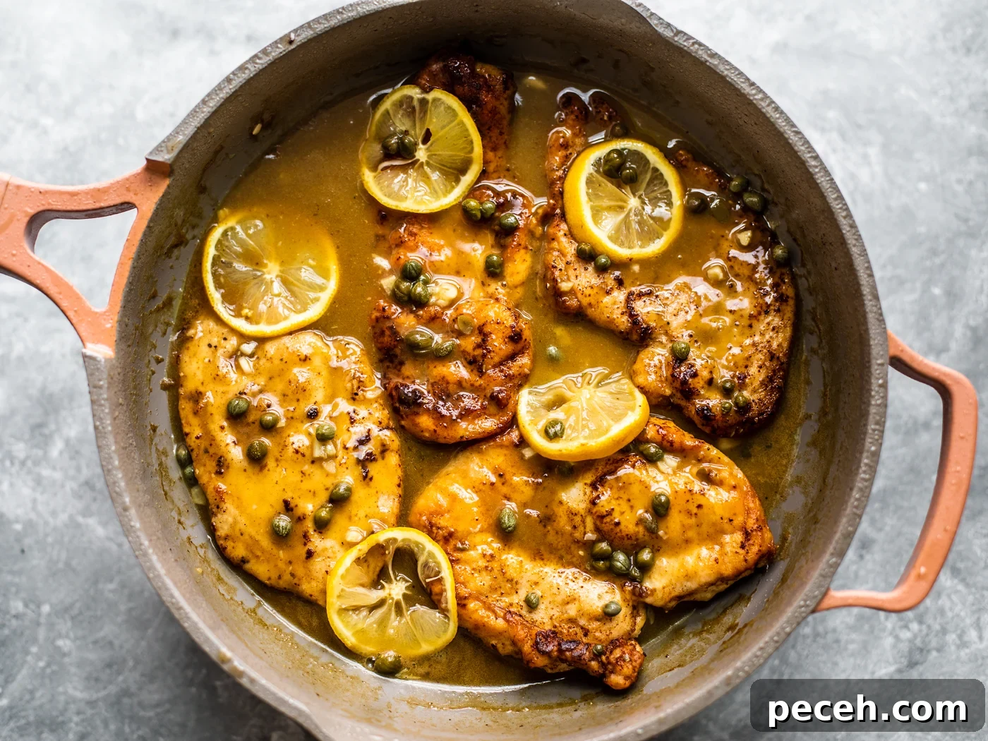 Classic Chicken Piccata Recipe with Lemon & Capers 7 Golden chicken cutlets in skillet with sauce, capers, and lemon slices.