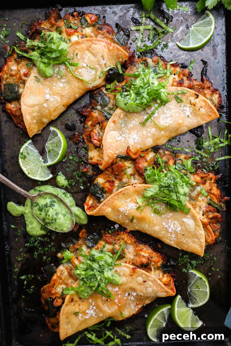 Crispy Poblano Chicken Tacos with Avocado Jalapeño Salsa 2 4 crispy poblano chicken tacos sitting on a large baking sheet topped with avocado-jalapeño salsa and shredded lettuce surrounded by fresh lime wedges
