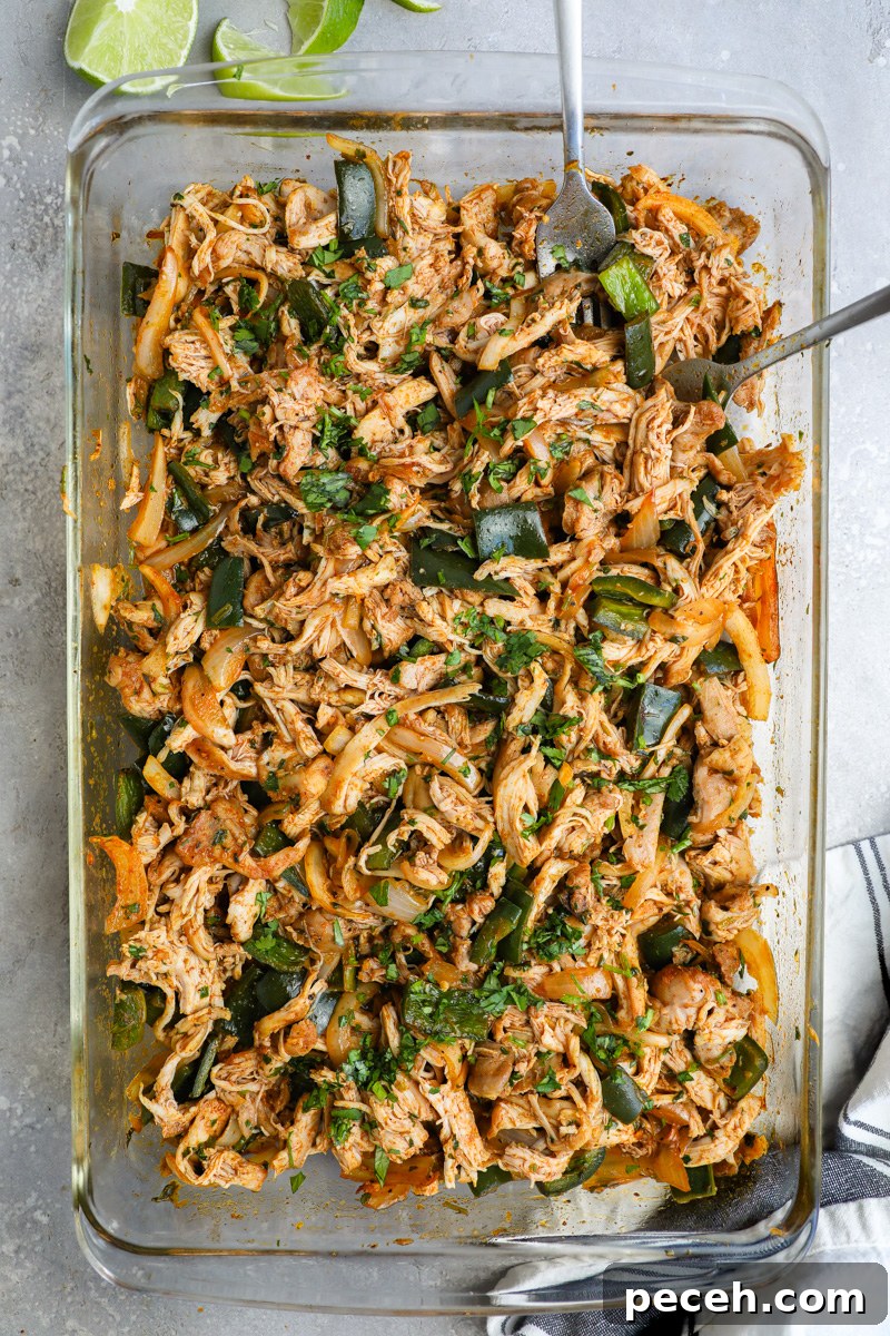 Crispy Poblano Chicken Tacos with Avocado Jalapeño Salsa 5 A large baking dish filled with shredded poblano chicken used as a filling for tacos