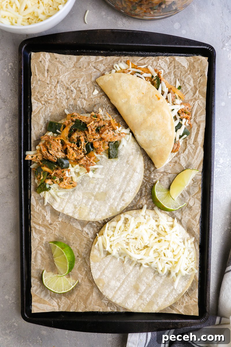 Crispy Poblano Chicken Tacos with Avocado Jalapeño Salsa 6 A large baking sheet filled with 3 tacos showing the 3 stages of making crispy chicken tacos