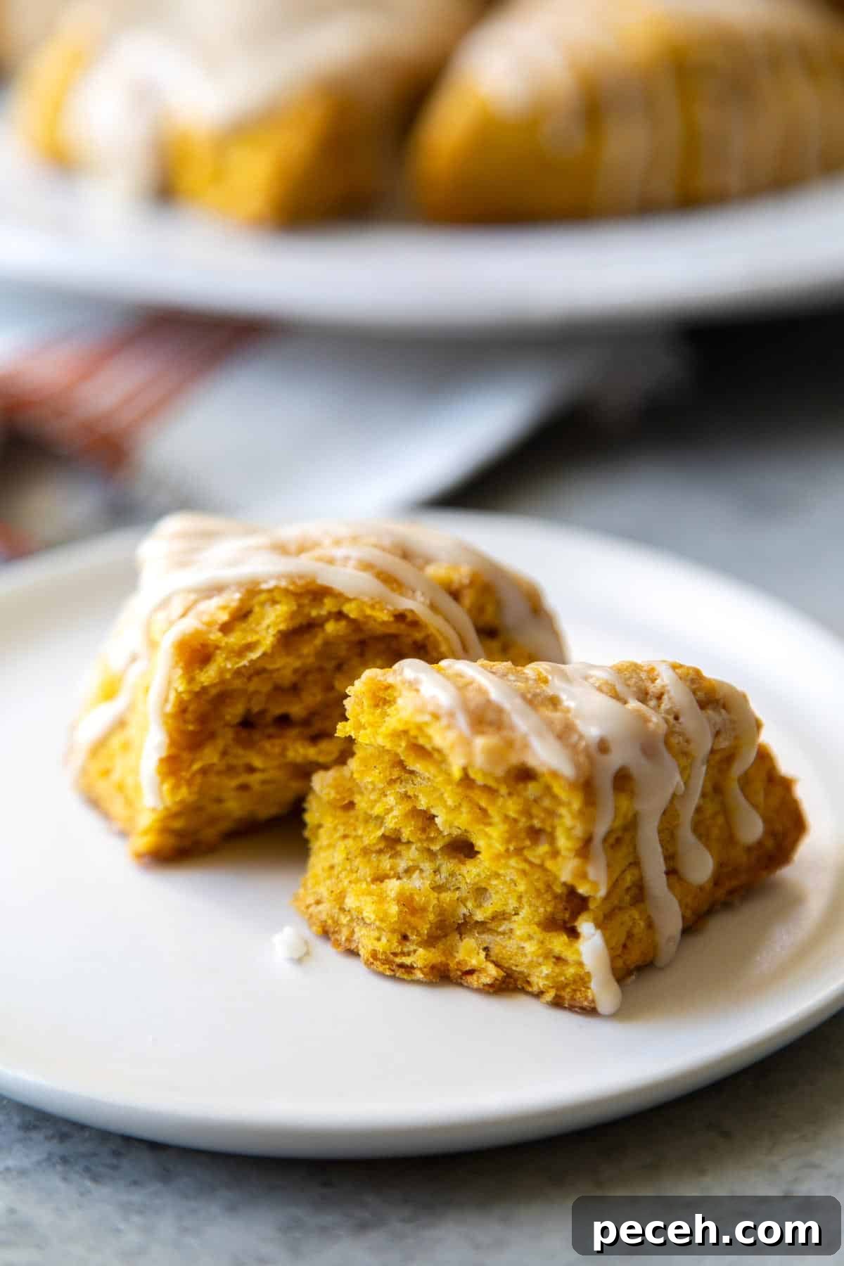 Maple-Glazed Pumpkin Scones Recipe for Fall Baking 4 interior shot of pumpkin scone wedge with maple glaze drizzle.