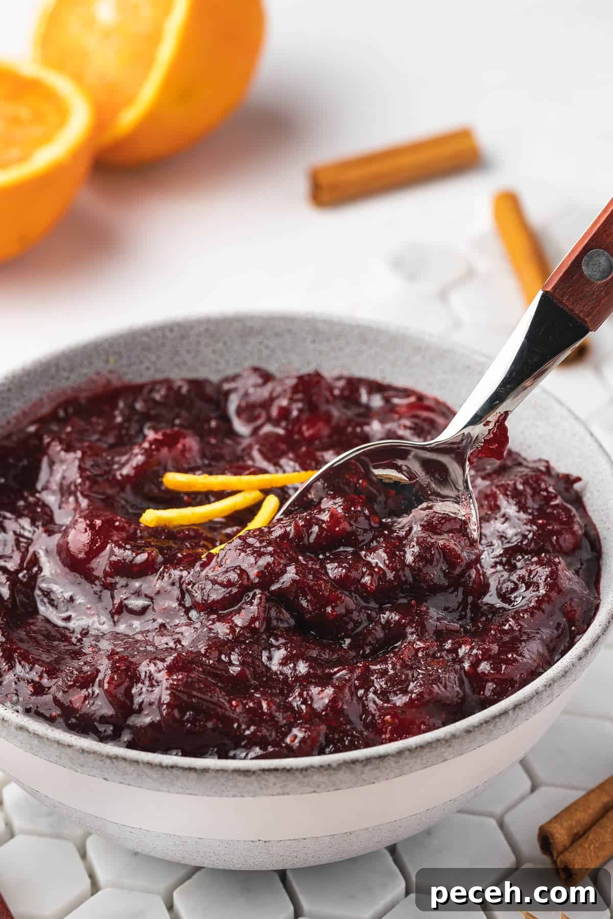 Slow Cooker Cranberry Sauce Recipe for Thanksgiving 7 A spoon tucked into a bowl of slow cooker cranberry sauce.