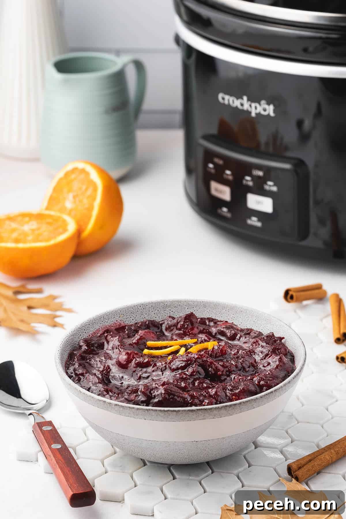Slow Cooker Cranberry Sauce Recipe for Thanksgiving 8 A bowl of cranberry sauce with a crockpot in the background.