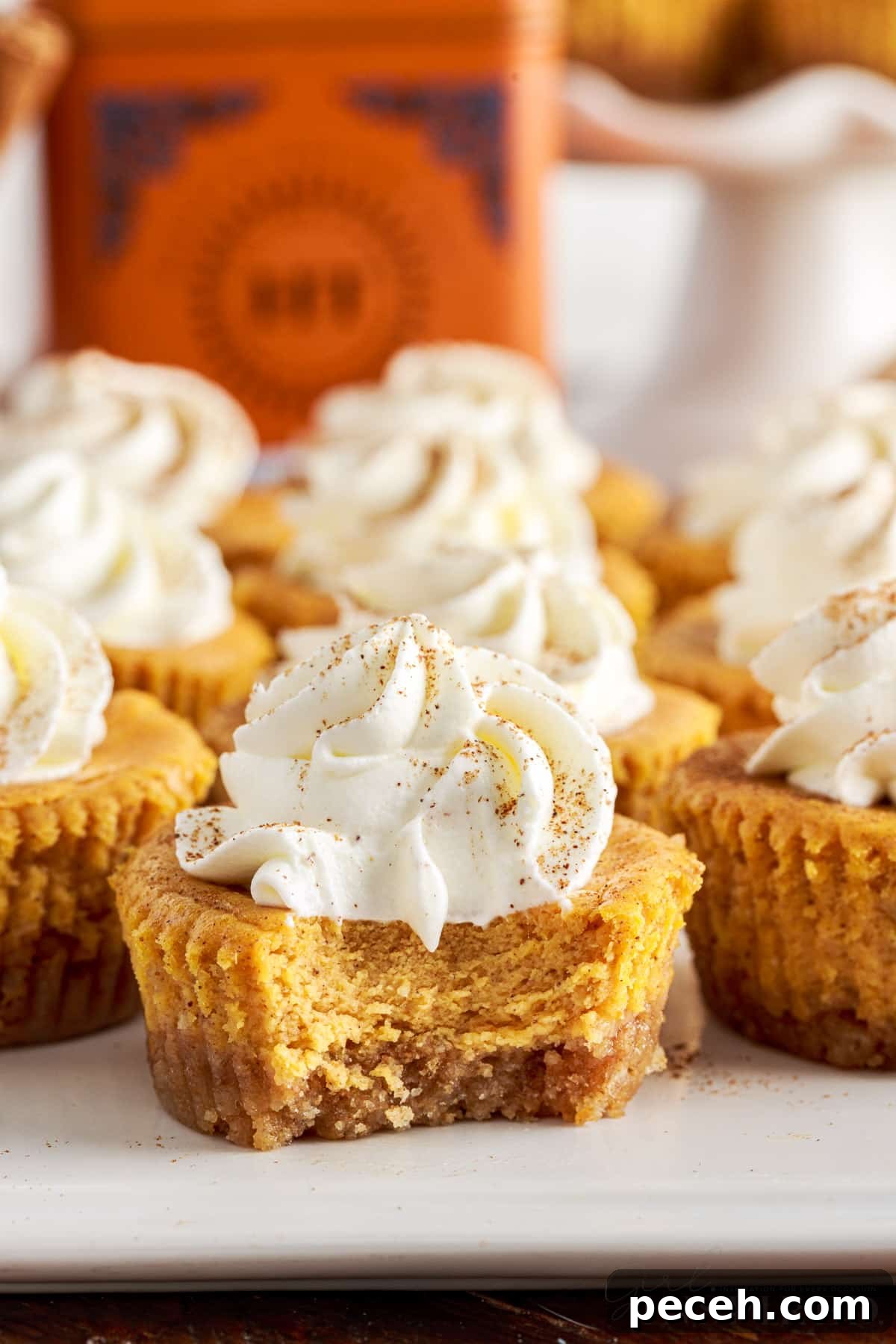 Mini pumpkin cheesecakes on a platter with a bite taken from one