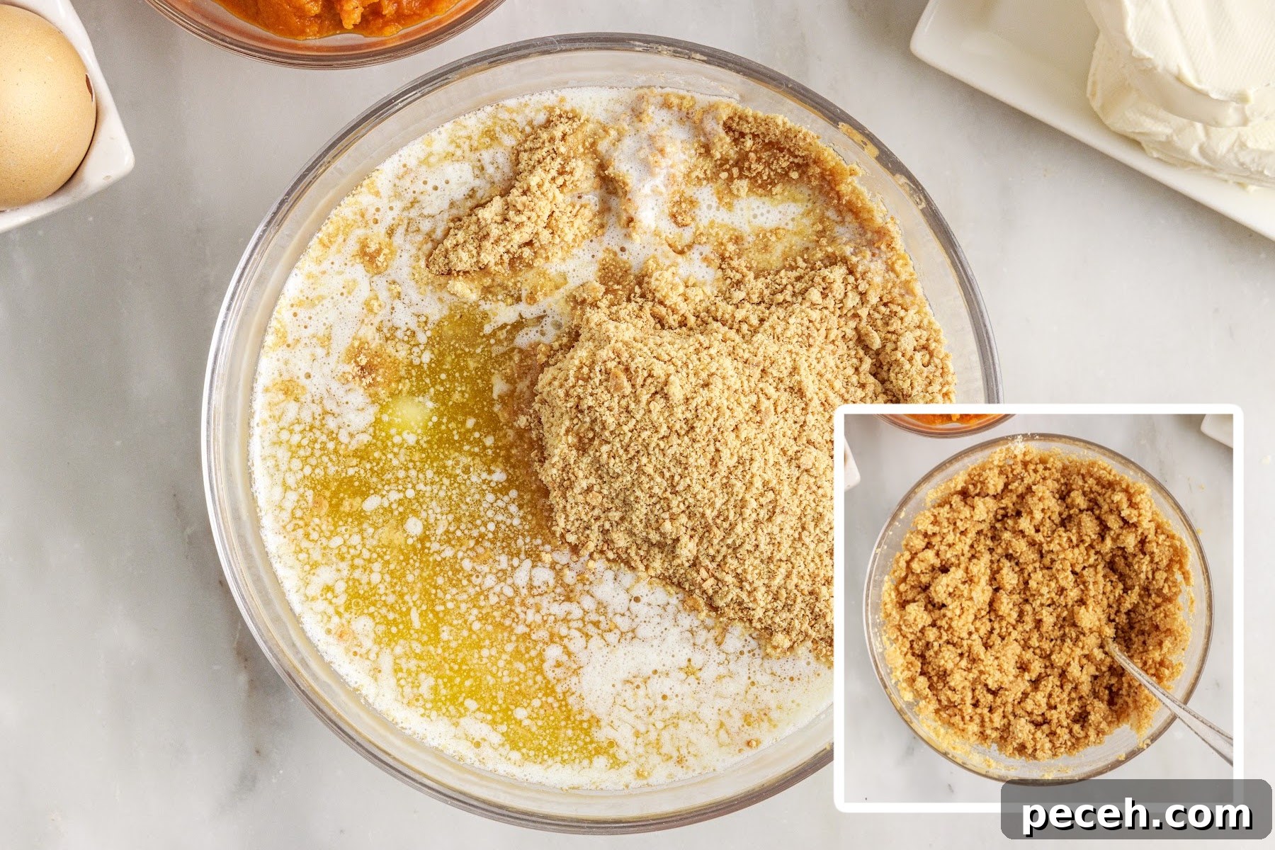 Graham cracker crumbs, sugar, and butter being combined in a glass mixing bowl into graham cracker crust.