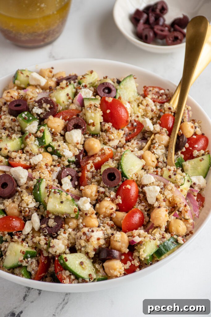 Greek Quinoa and Chickpea Salad with Feta and Olives 2 A white bowl filled with greek quinoa chickpea salad.