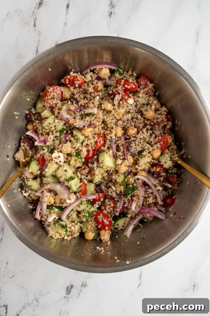 Greek Quinoa and Chickpea Salad with Feta and Olives 6 A stainless steel bowl filled with greek quinoa salad with chickpeas.