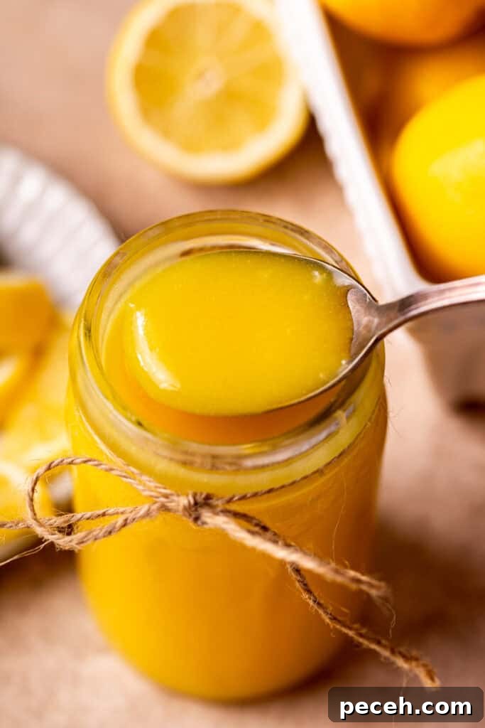 Taking a spoon of lemon curd out of the jar.