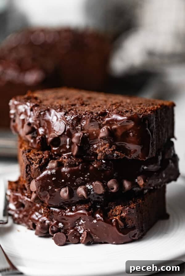 Chewy Banana Chocolate Chip Cookies Recipe for Perfect Bakes 12 sliced chocolate banana bread stacked on top of each other with chocolate chips and chocolate ganache glaze on top.
