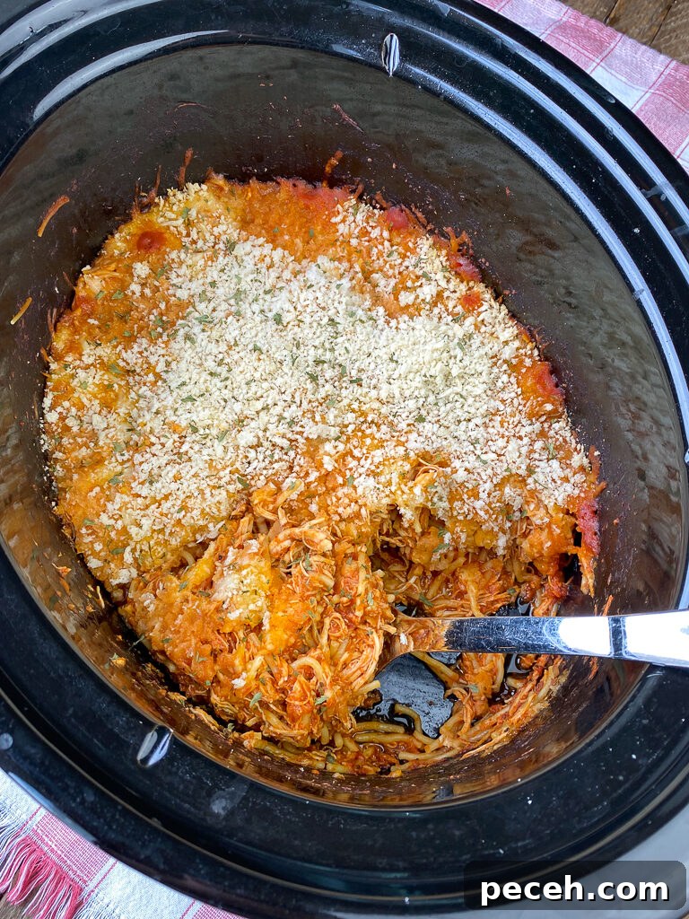 One-Pot Slow Cooker Chicken Parmesan Recipe 3 Serving spoon scooping out the corner of one pot parmesan chicken in a crock pot