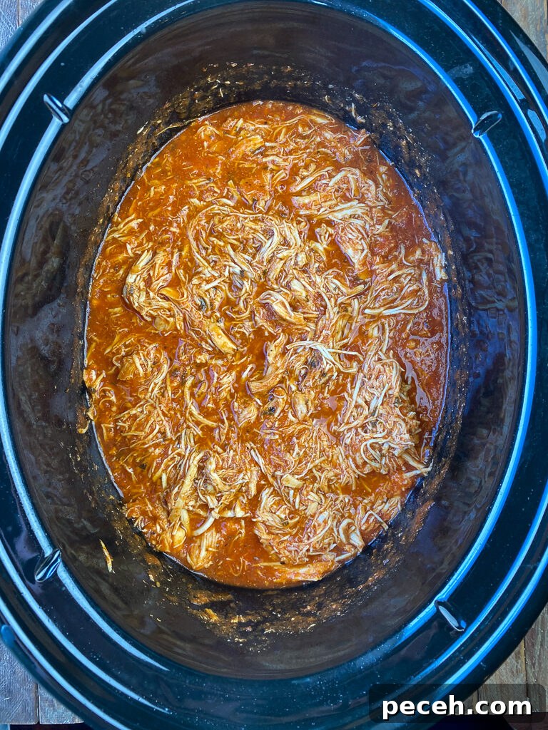 One-Pot Slow Cooker Chicken Parmesan Recipe 8 Shredded parmesan chicken in tomato sauce in a black slow cooker