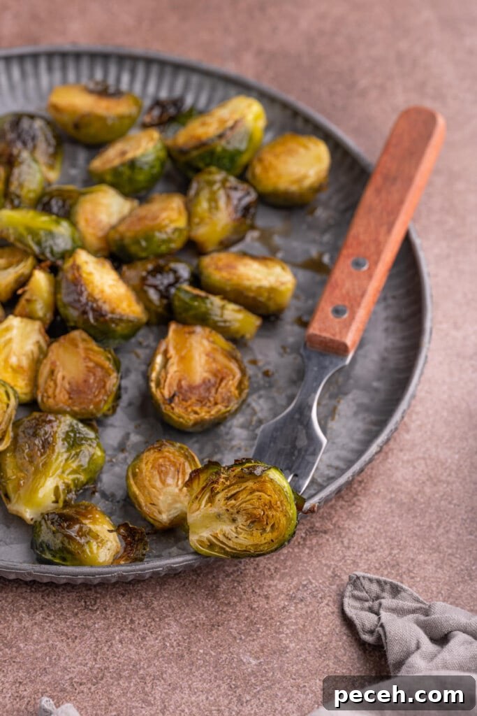 Maple-Balsamic Roasted Brussels Sprouts Recipe for Fall sides 2 Maple Balsamic Brussels Sprouts with one on a fork
