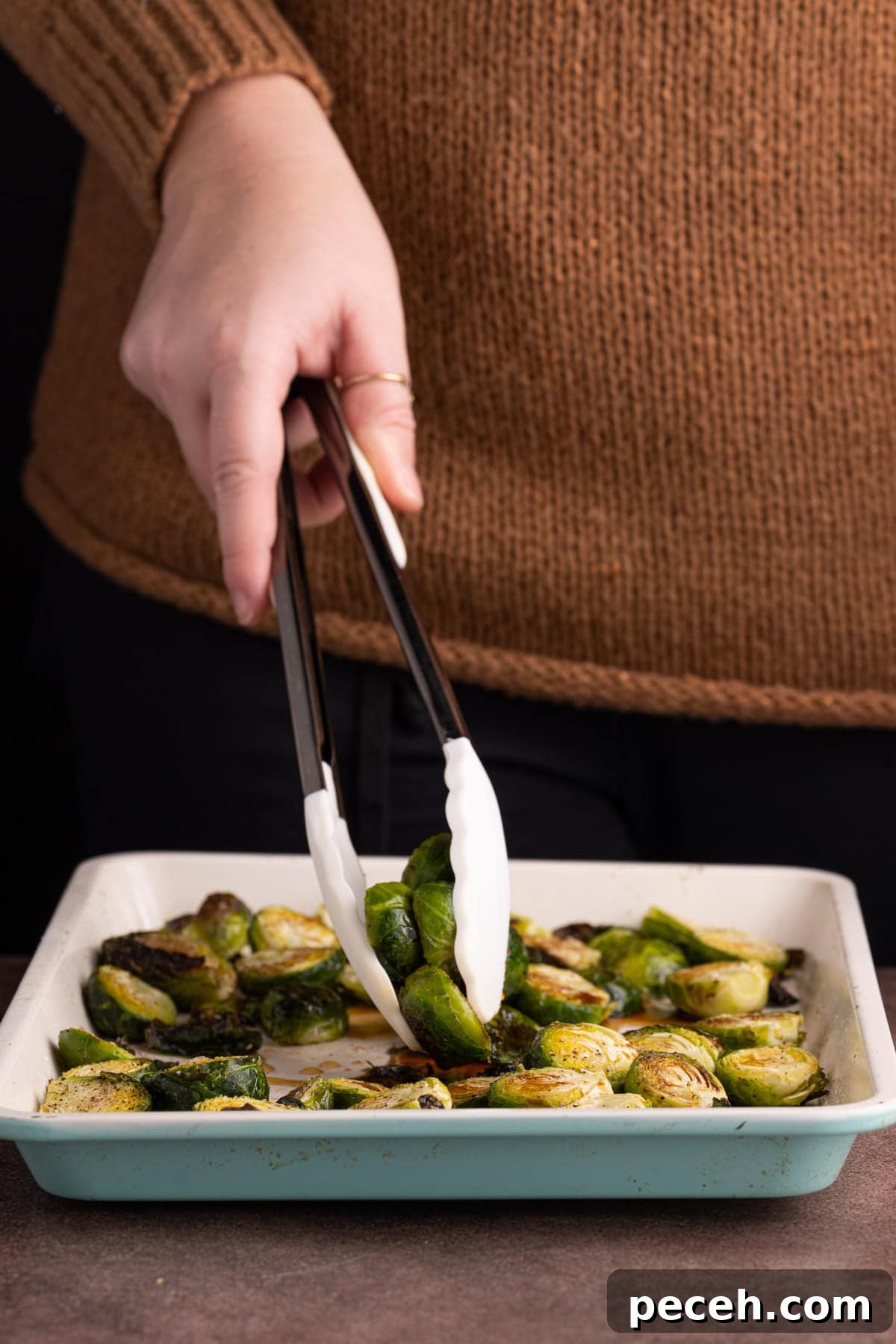 Maple-Balsamic Roasted Brussels Sprouts Recipe for Fall sides 9 Tossing hot brussels sprouts in maple syrup and balsamic vinegar.