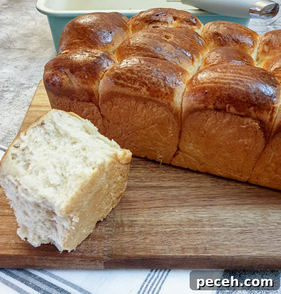 Mosbolletjies (Condensed Milk Rusks): South African Sweet Biscuits 13 A piece of mosbolletjie in front of a loaf of baked rusks.