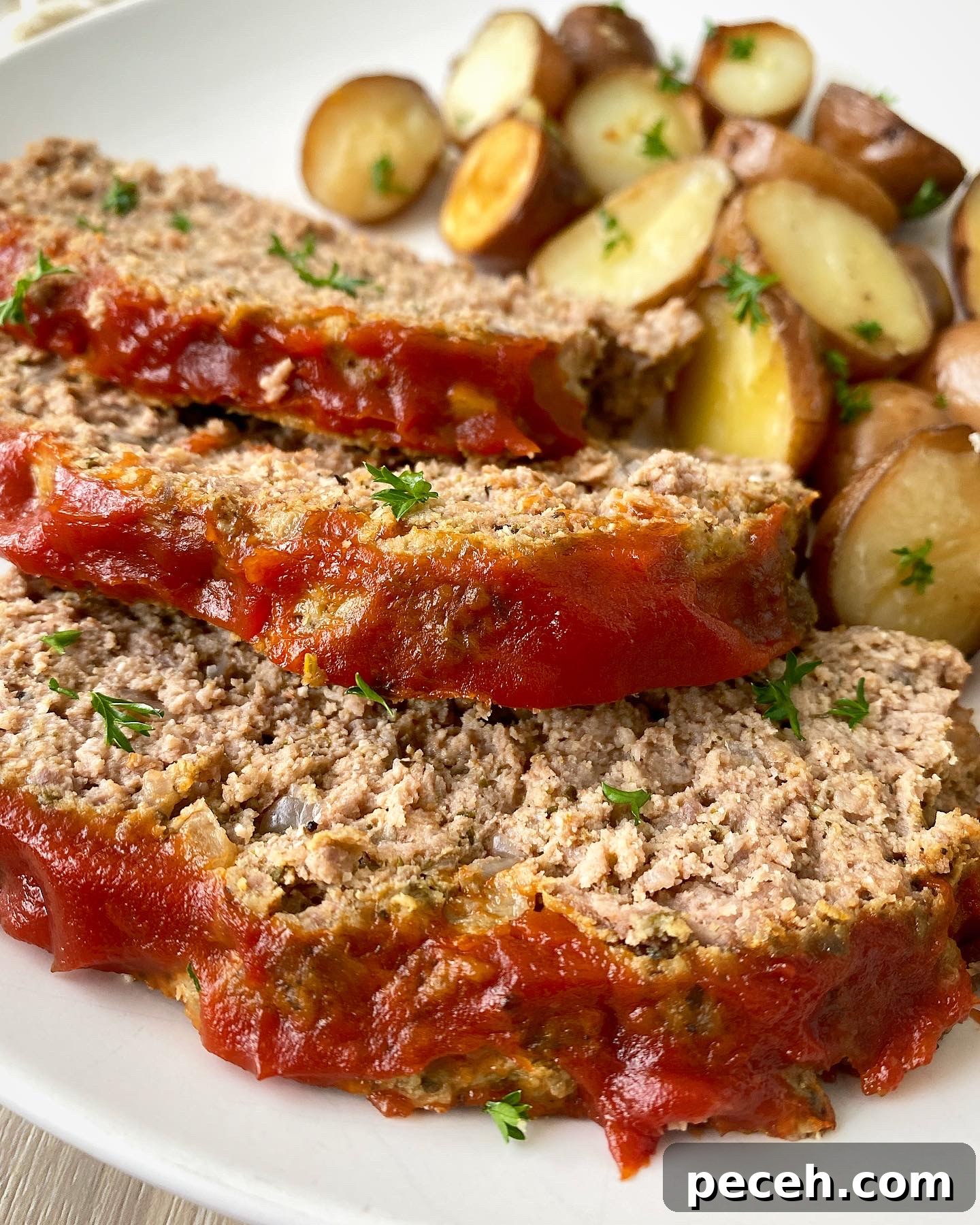 Slow Cooker Meatloaf with Potatoes (Video Recipe) 6 close up shot of meatloaf and potatoes on a white plate