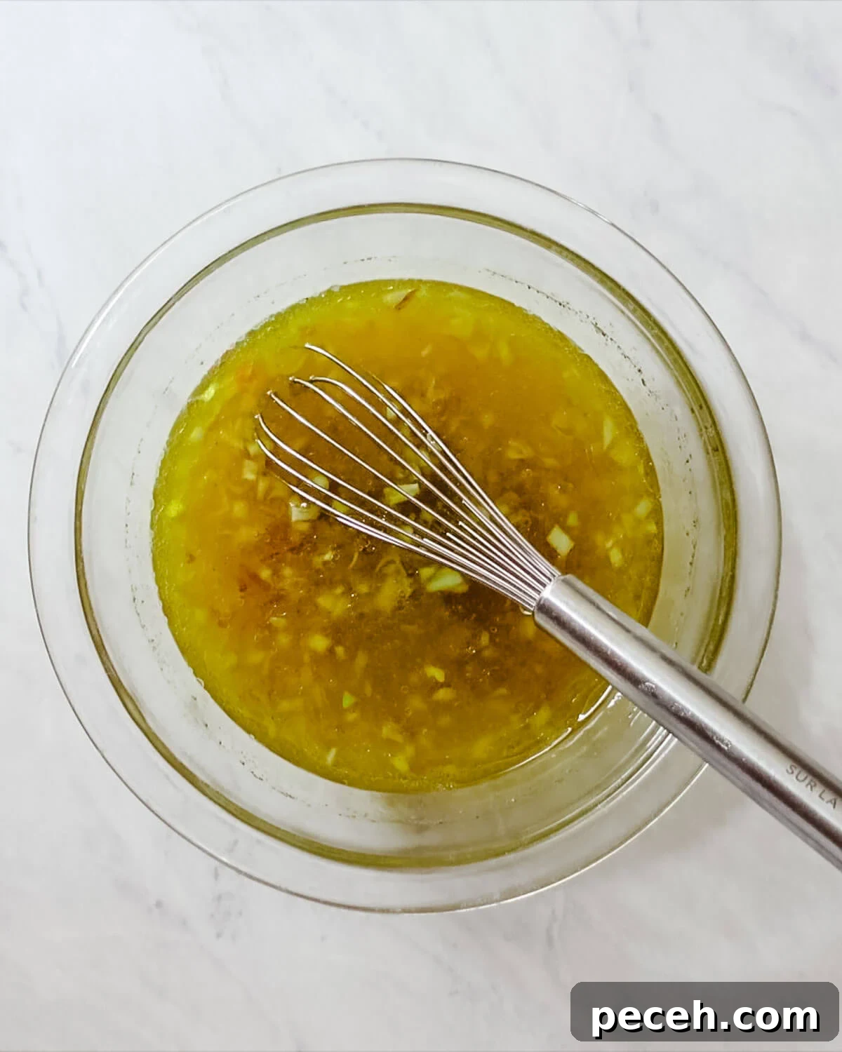 Whisk salad dressing in a bowl.