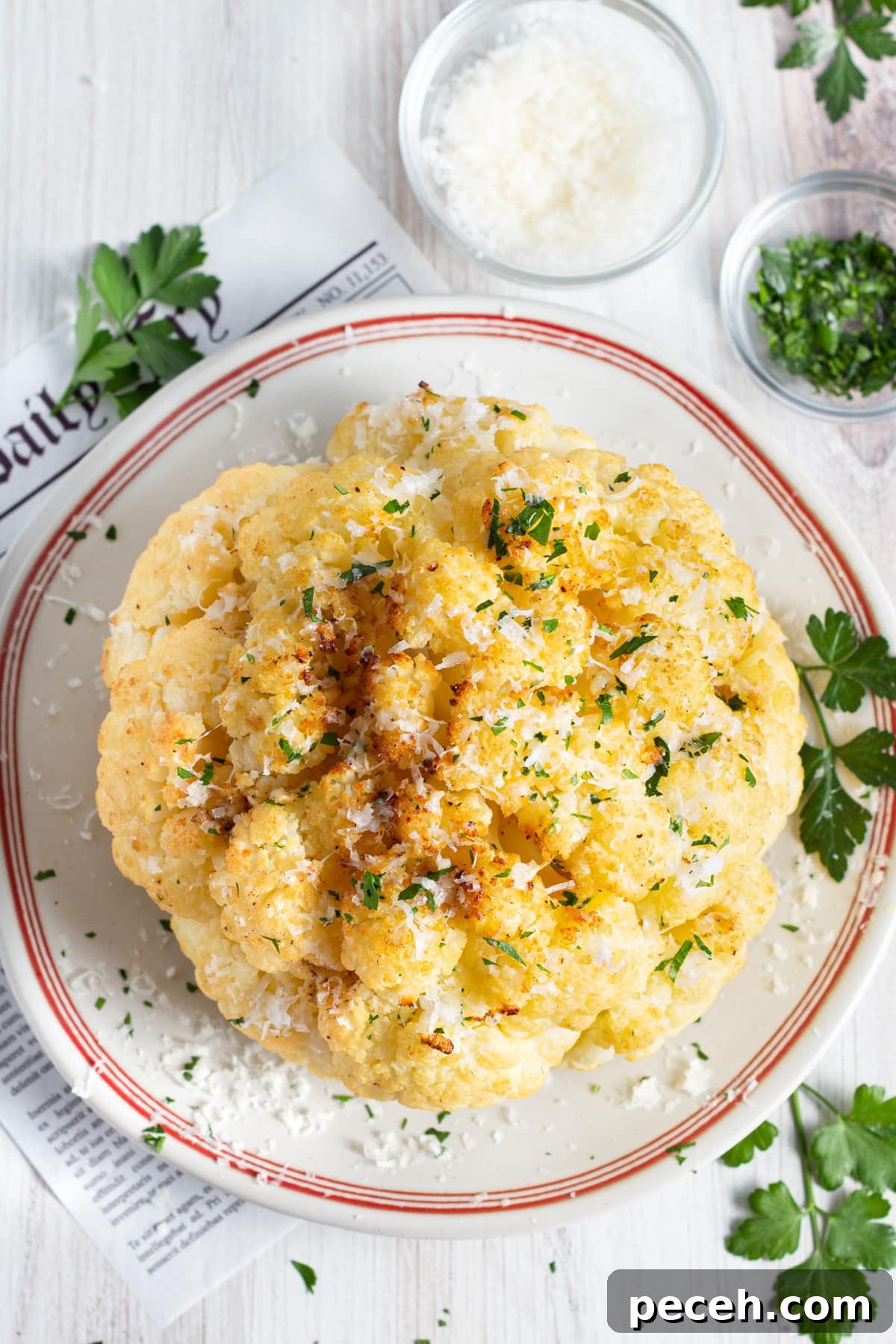 Smoked Cauliflower Recipe: Tender, Smoky Vegetable Side Dish 13 Picture of the cauliflower cooked in a plate with bowls of parmesan and parsley.