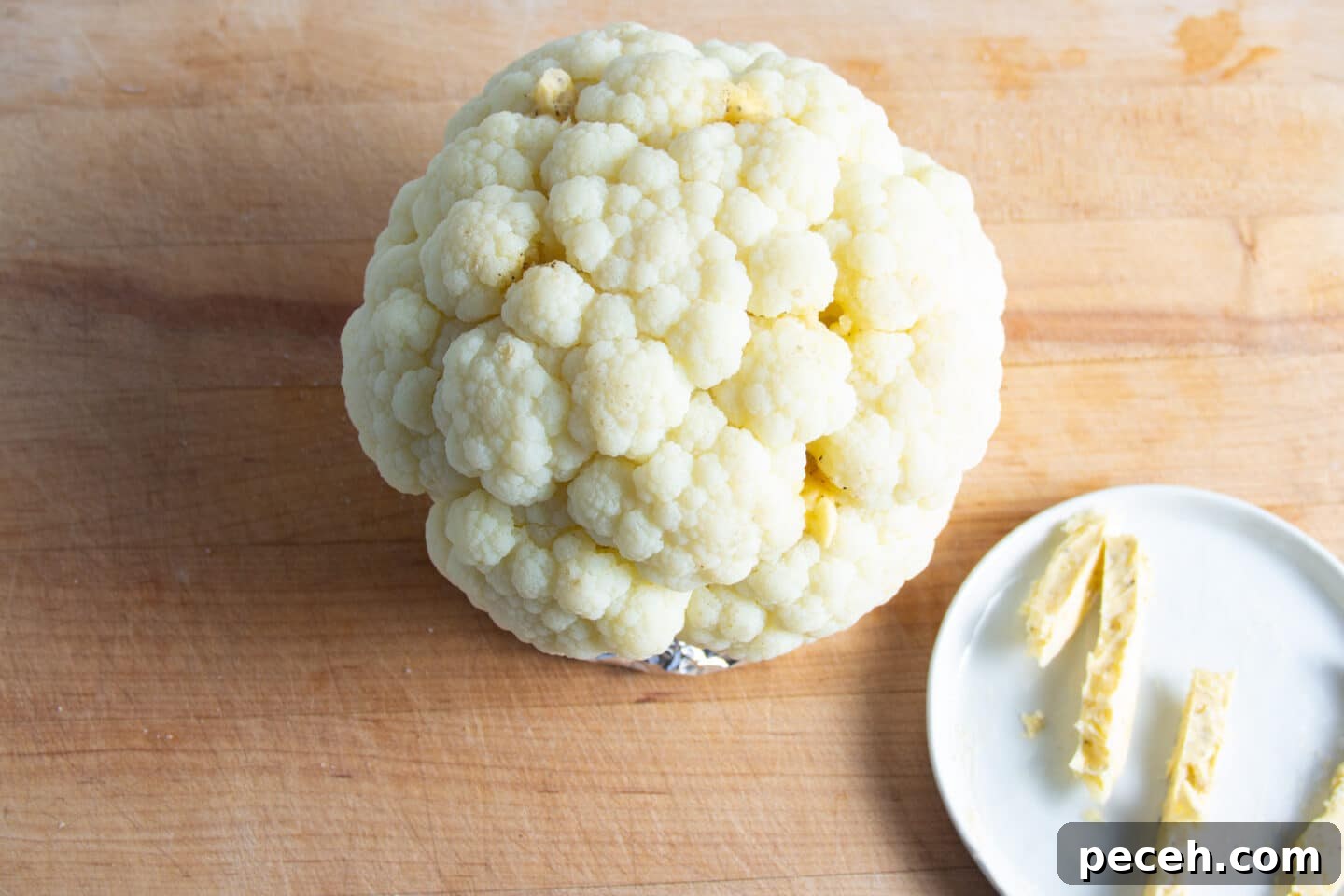 Smoked Cauliflower Recipe: Tender, Smoky Vegetable Side Dish 6 Picture of cauliflower being rubbed with butter.