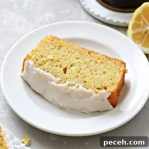 Dairy-Free Lemon Drizzle Cake Recipe — Zesty Moist Loaf 7 A slice of Dairy Free Lemon Drizzle Cake with coffee to the side.