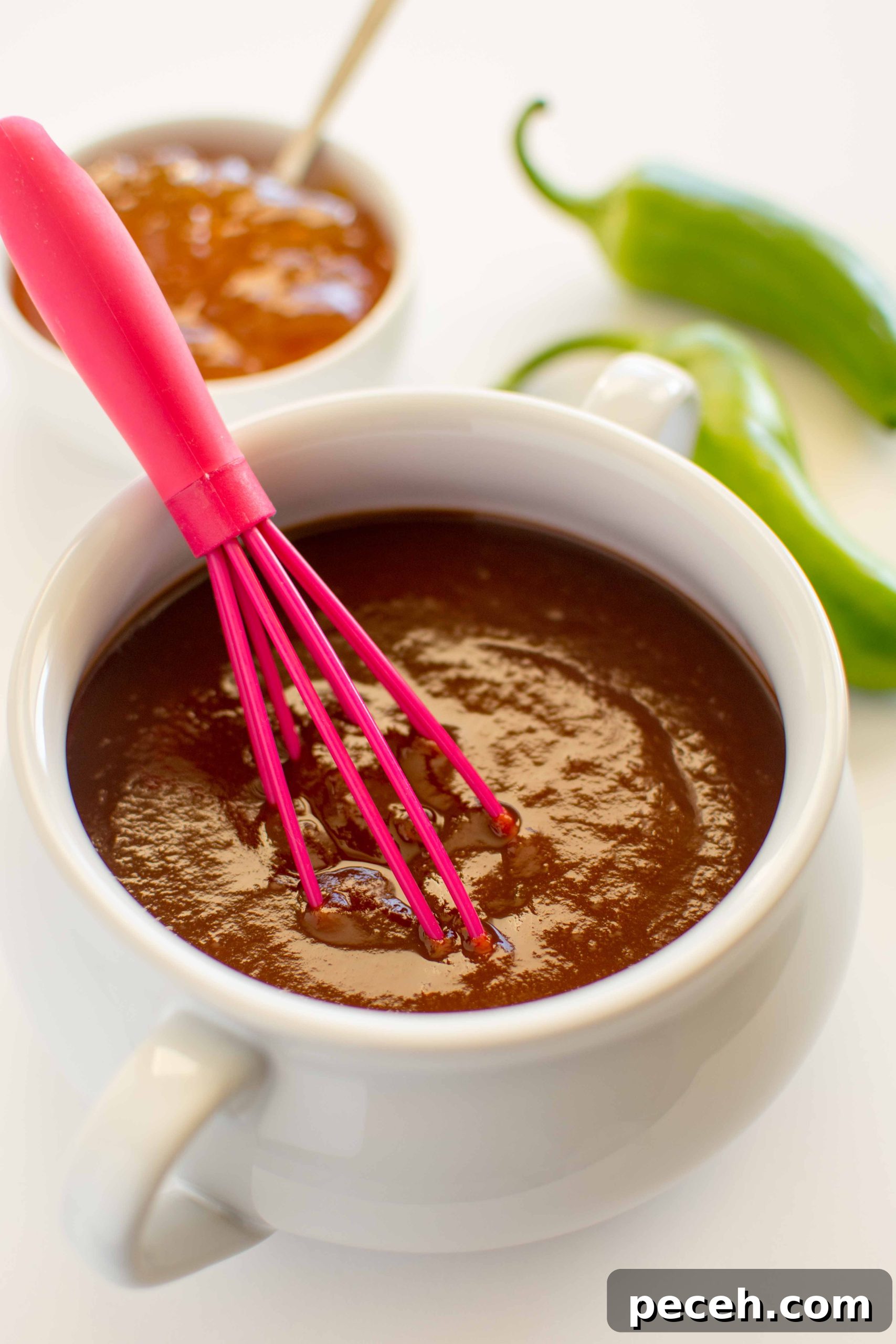 bbq sauce in white bowl with pink whisk