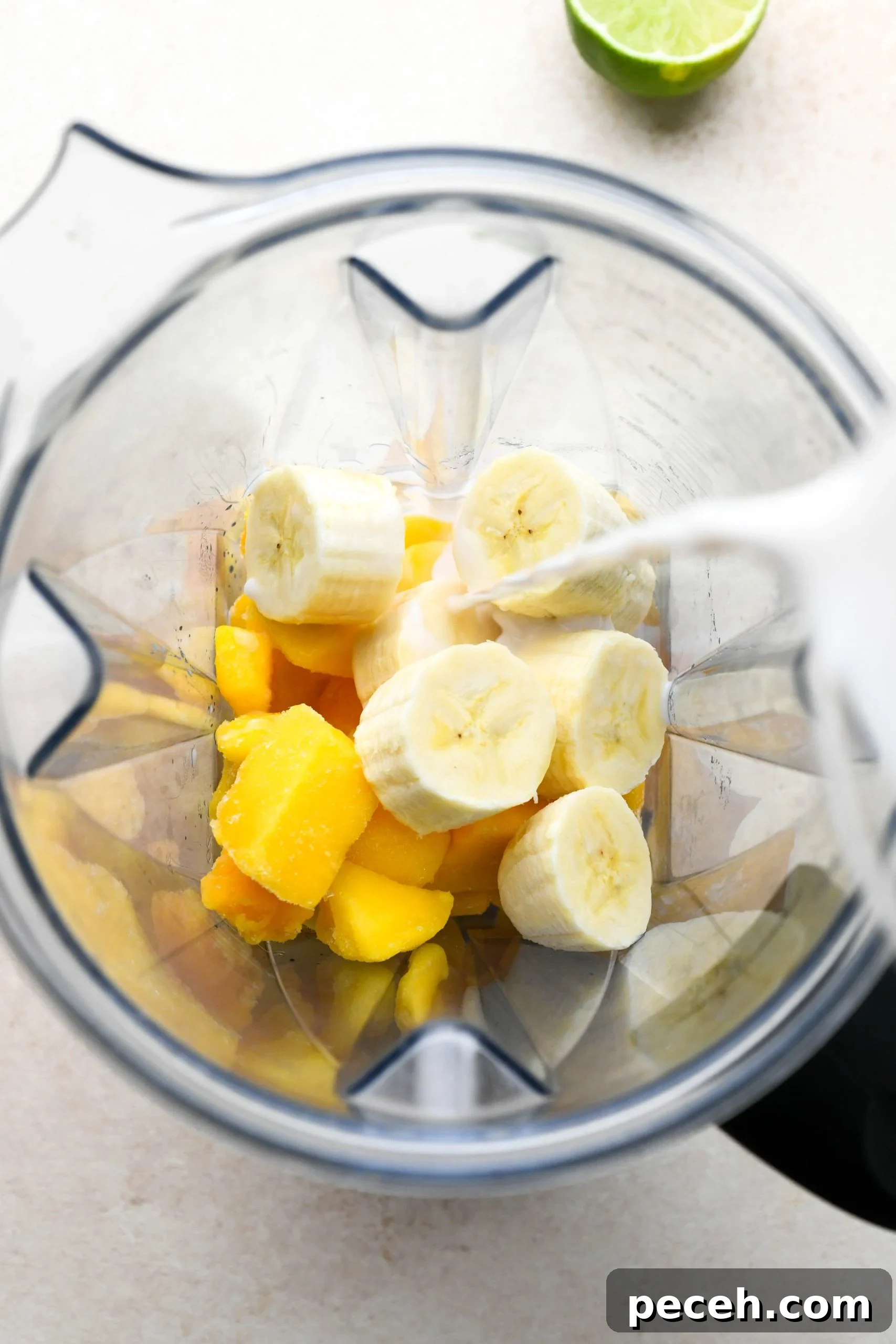 5-Minute Dairy-Free Frozen Mango Smoothie Recipe 5 How to make a simple mango smoothie: pouring non dairy milk into the blender with all the other smoothie ingredients.