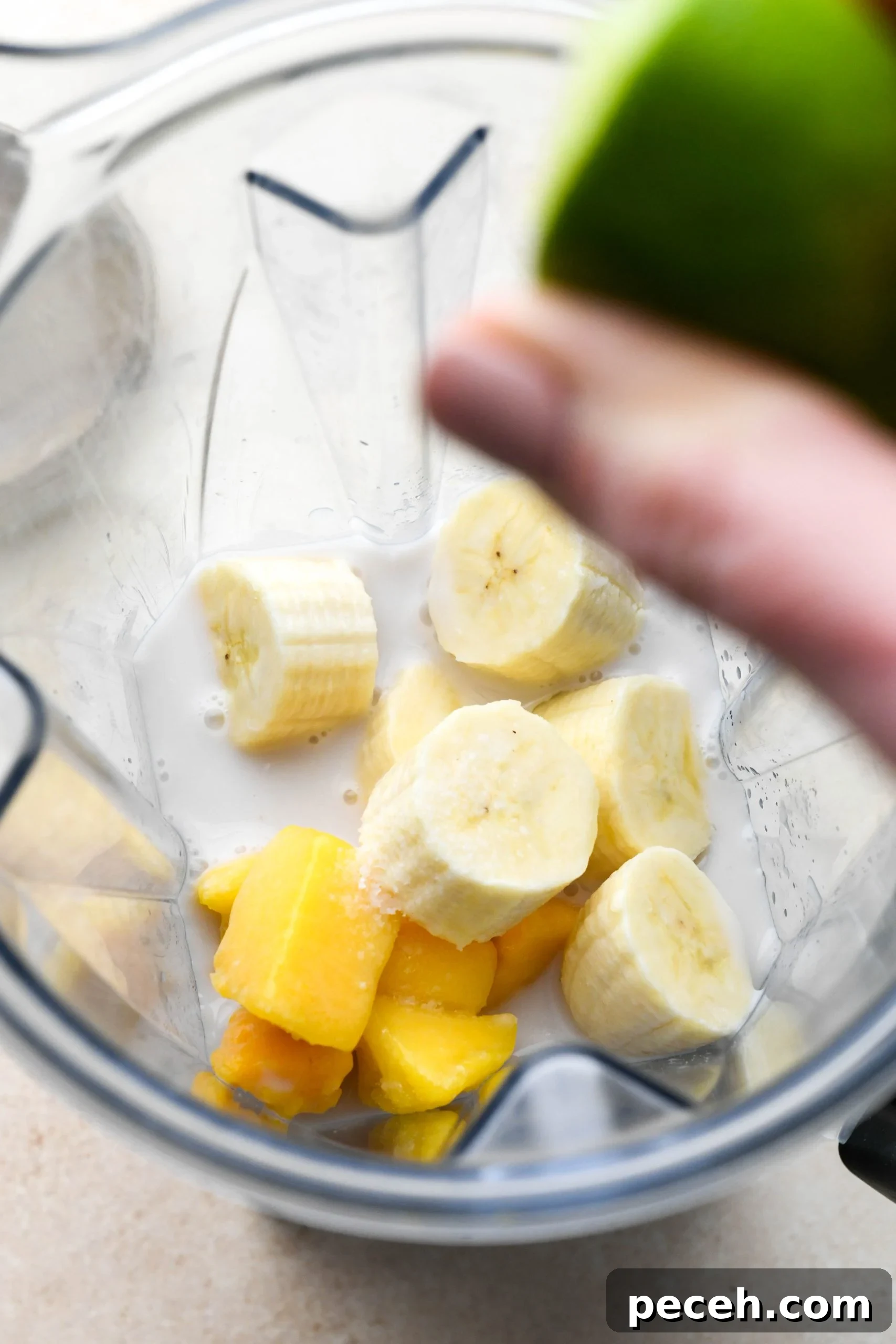 5-Minute Dairy-Free Frozen Mango Smoothie Recipe 6 How to make a simple mango smoothie: squeezing a lime into the blender with all the other smoothie ingredients.