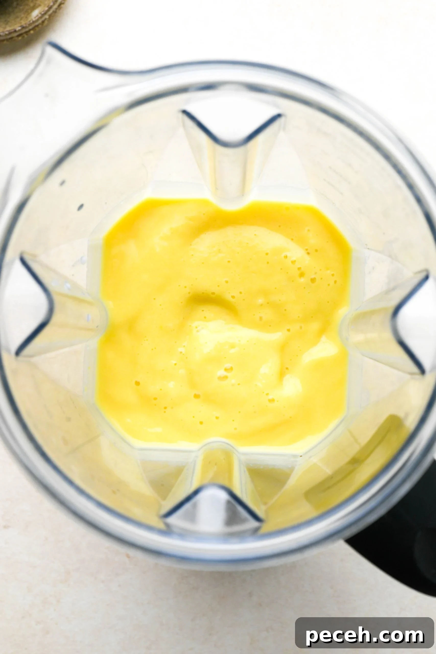5-Minute Dairy-Free Frozen Mango Smoothie Recipe 7 How to make a simple mango smoothie: mango smoothie smooth and blended inside blender container.