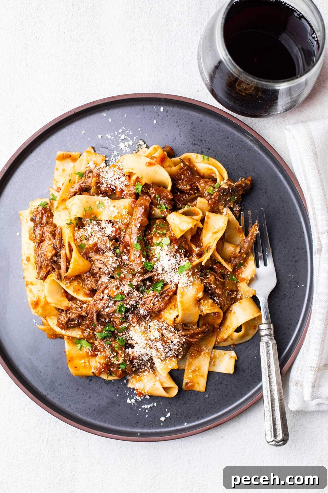 Braised Beef Short Rib Ragu Recipe — Slow-Cooked Italian Comfort 2 A plate with beef short rib ragu served on top of pappardelle pasta.