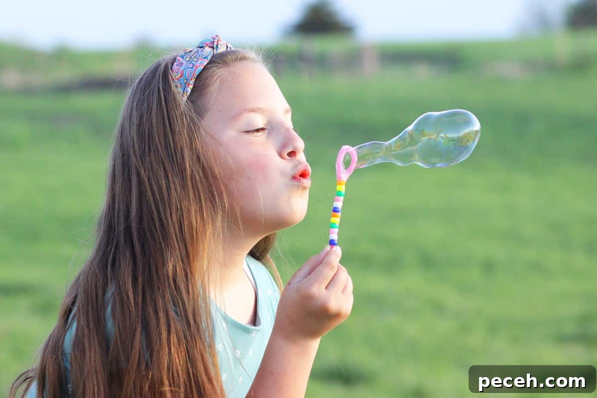 How to Make Long-Lasting Soap Bubbles with Glycerin 4 a girl blowing bubbles with a homemade bubble wand