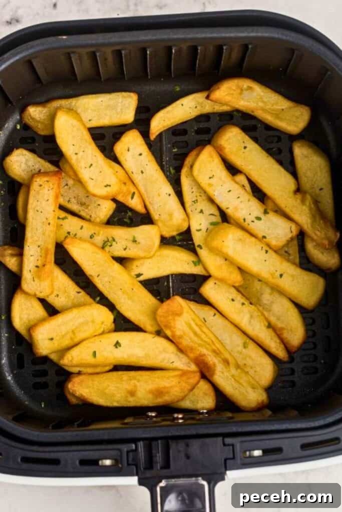 Crispy steak fries in the air fryer basket after being cooked