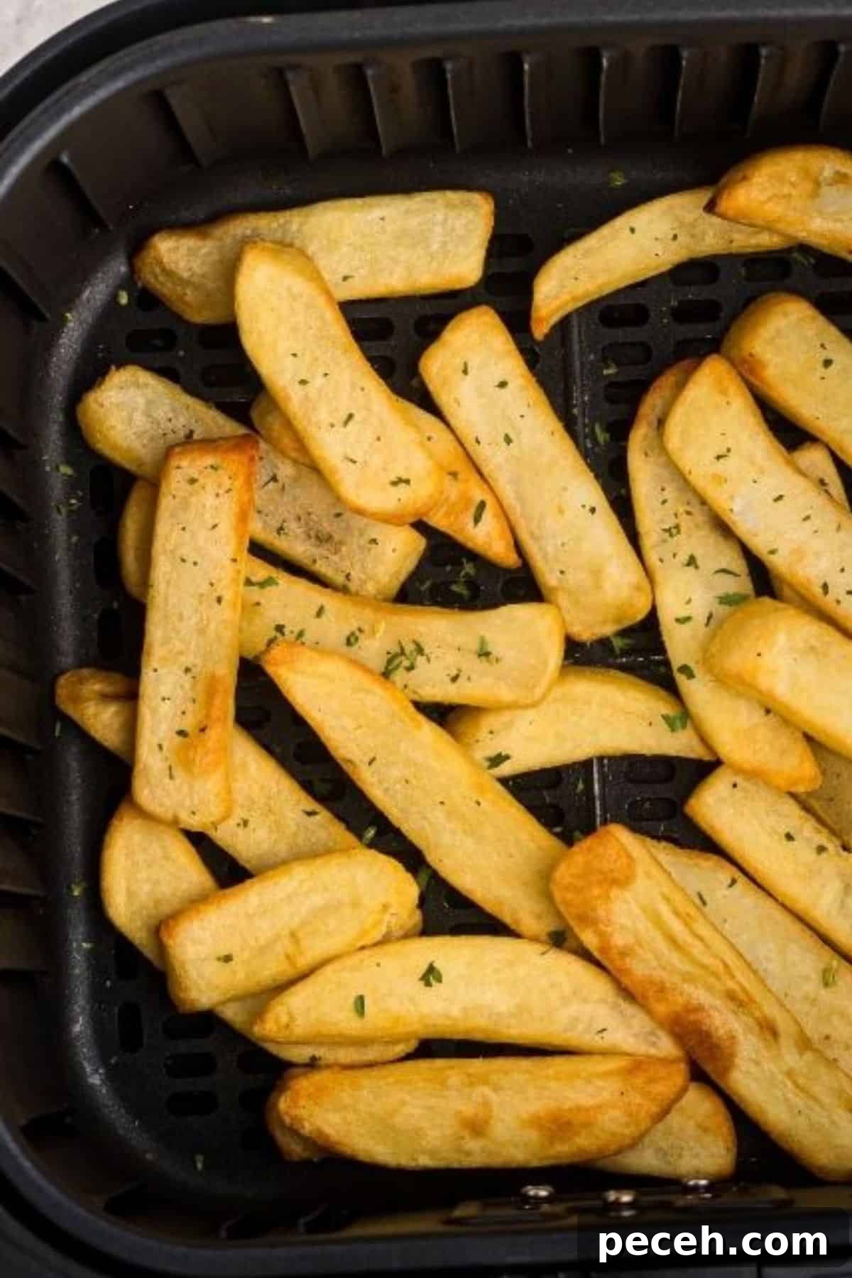 Crispy steak fries in the air fryer basket after being cooked