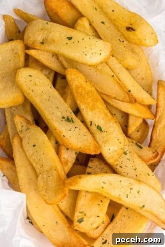 Air fryer steak fries stacked in a bowl after being cooked and seasoned.