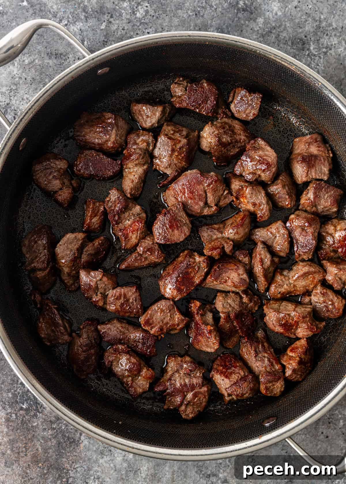 Authentic Jordanian Mansaf Recipe: Traditional Bedouin Feast 5 overhead process shot: cut lamb seasoned with salt and pepper, seared it in a Dutch oven